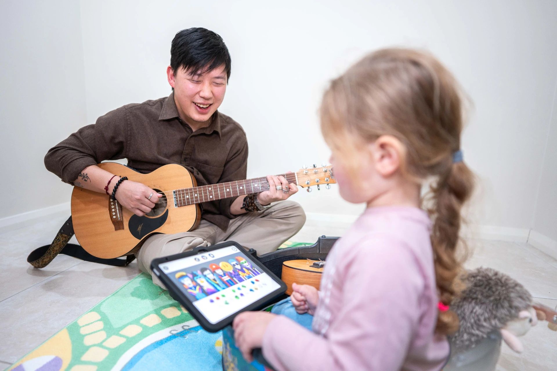 Music therapist playing guitar with a child during a relaxed, interactive session